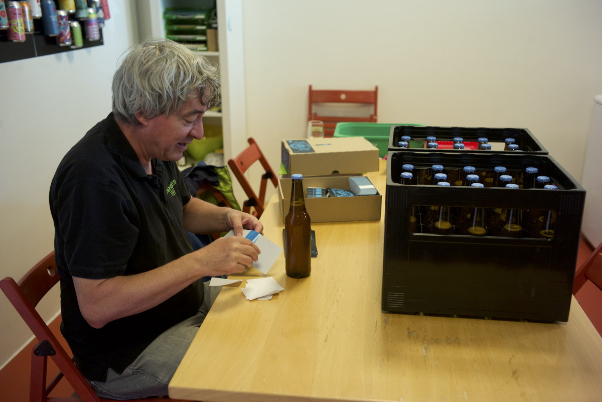 Dani am Etikettieren der abgefüllten Bierflaschen